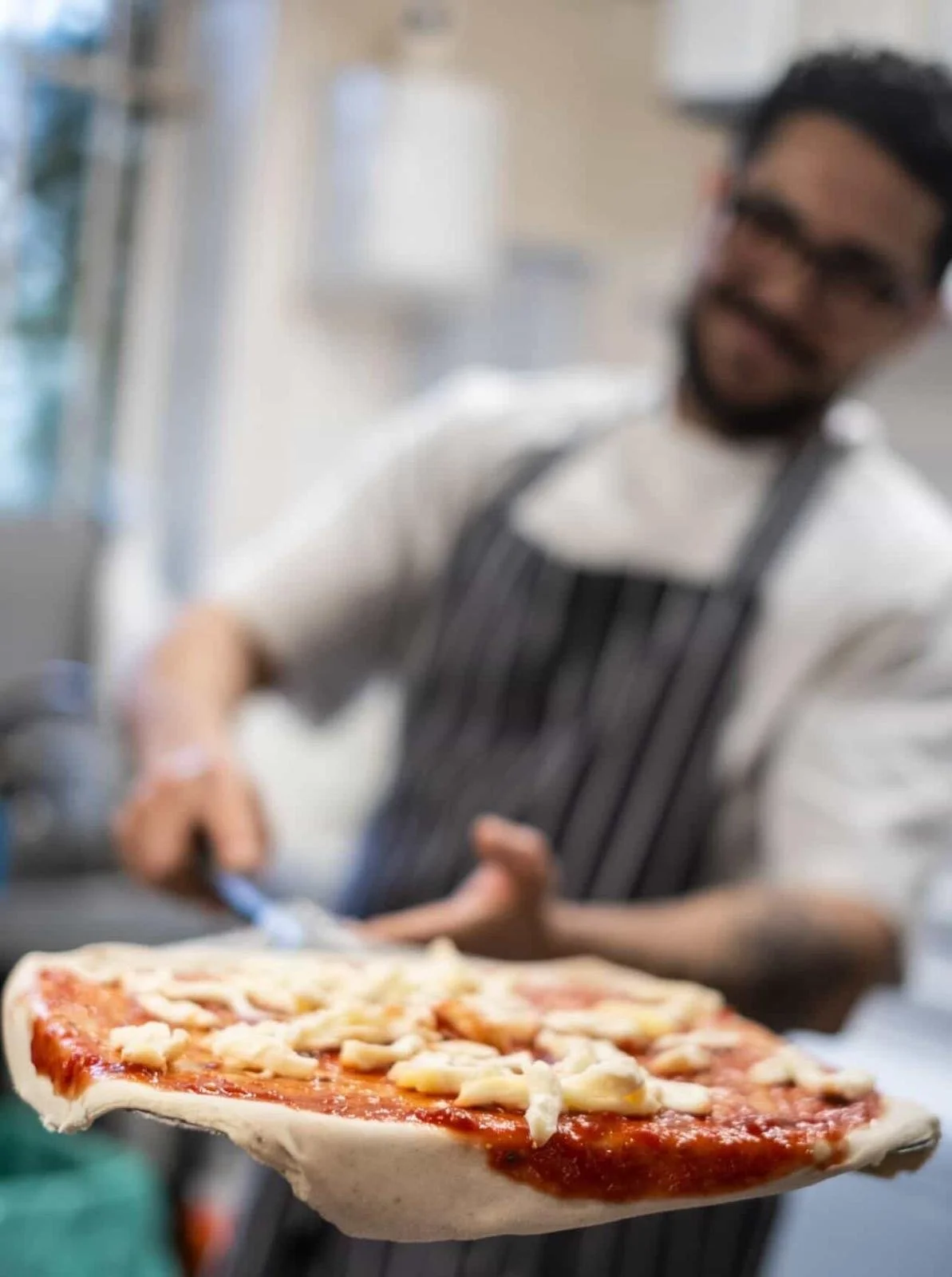 Pizzaiolo with a fresh pizza